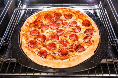Pepperoni pizza in the oven. clipart