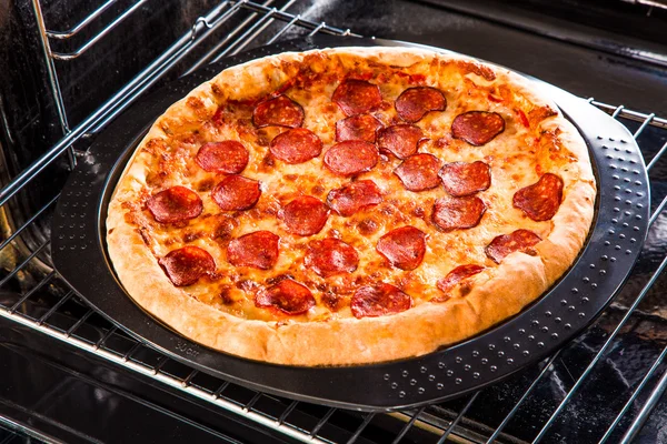 Pepperoni pizza i ugnen. — Stockfoto