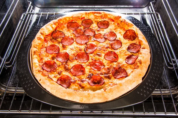 Pepperoni pizza i ugnen. — Stockfoto