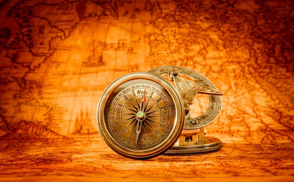 Vintage compass lies on an ancient world map. — Stock Photo, Image