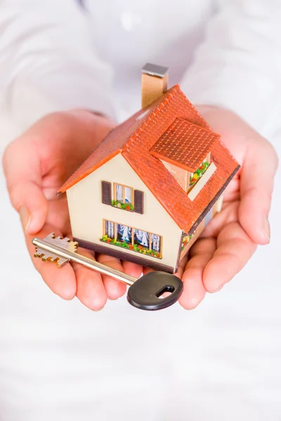 Huis in menselijke handen — Stockfoto