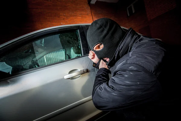 Auto dief in een masker. — Stockfoto