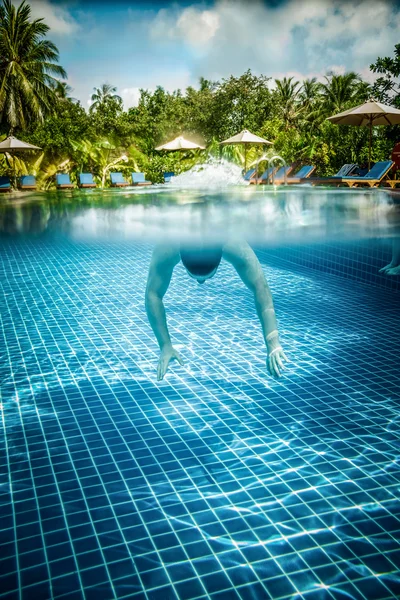 Homem flutua subaquático na piscina — Fotografia de Stock