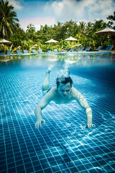 男子水下漂浮在游泳池中 — 图库照片