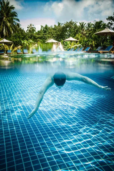 Человек плавает под водой в бассейне — стоковое фото