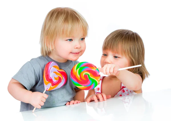 Babies eating a sticky lollipop — Stock Photo, Image