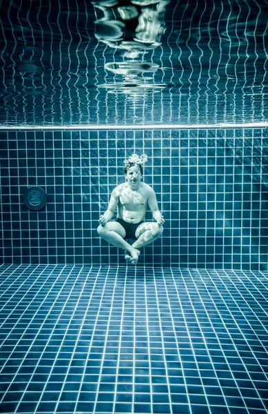 Człowiek pod wodą w basenie, zrelaksować się w pozycji lotosu — Zdjęcie stockowe