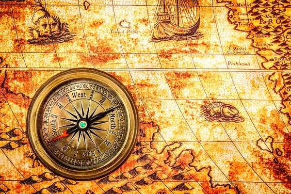 Vintage kompas ligt op een oude wereldkaart. — Stockfoto