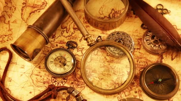 Loupe vintage, boussole, télescope et une montre de poche couchée sur la carte du monde antique en 1565 . — Video