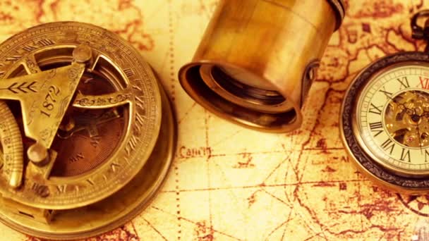 Винтажное лупа, компас, телескоп и карманные часы, лежащие на карте древнего мира в 1565 году . — стоковое видео