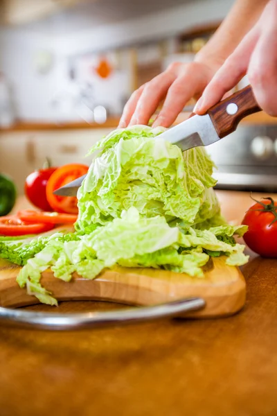 Las manos de mujer cortando verduras — Foto de Stock