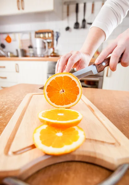 Las manos de la mujer corte naranja — Foto de Stock