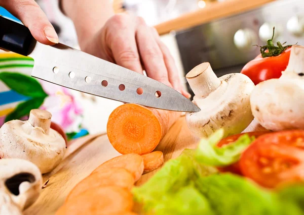 Las manos de mujer cortando verduras — Foto de Stock