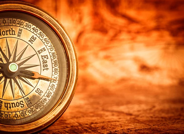 Vintage kompass ligger på en antika världskarta. — Stockfoto