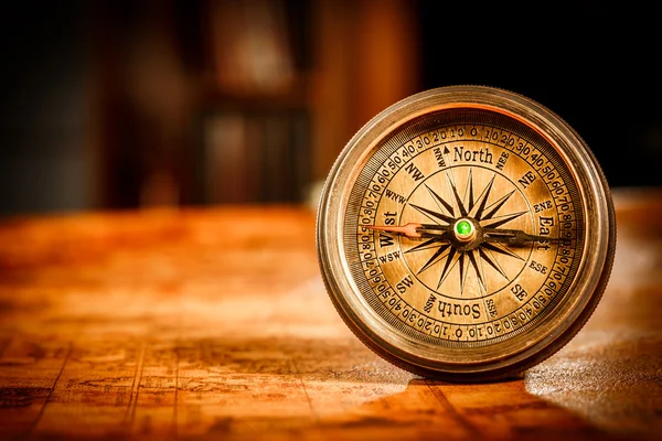 Jahrgangskompass liegt auf einer antiken Weltkarte. — Stockfoto