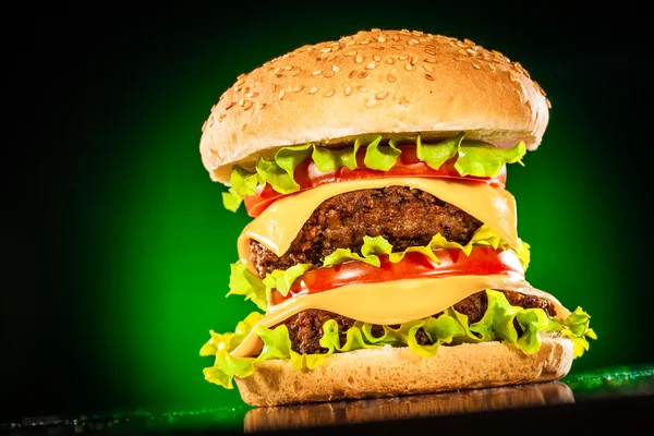 Hamburger gustoso e appetitoso su un verde scuro — Foto Stock