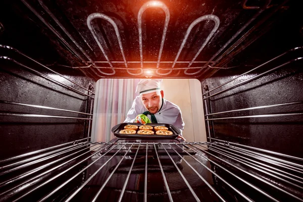 Cocinero cocina en el horno. — Foto de Stock