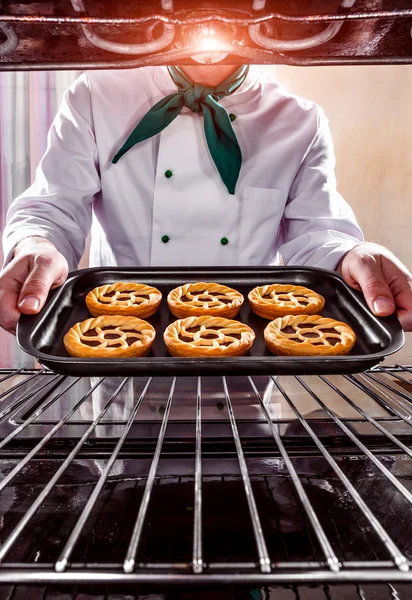 Cocinero cocina en el horno. — Foto de Stock