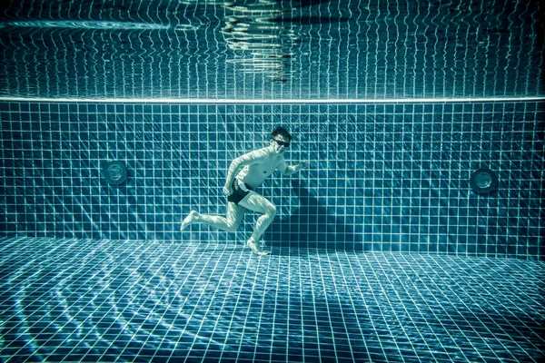 El hombre corre bajo el agua piscina — Foto de Stock