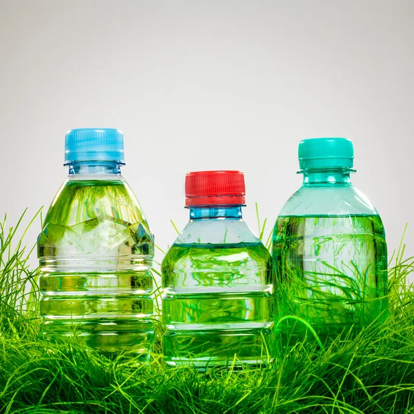 Botella de agua en la hierba —  Fotos de Stock