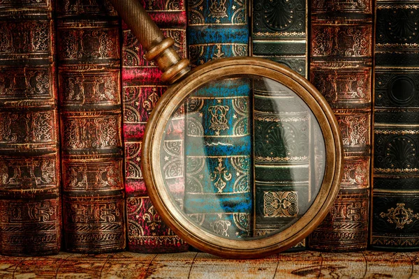 Ancient old books and magnifying glass — Stock Photo, Image