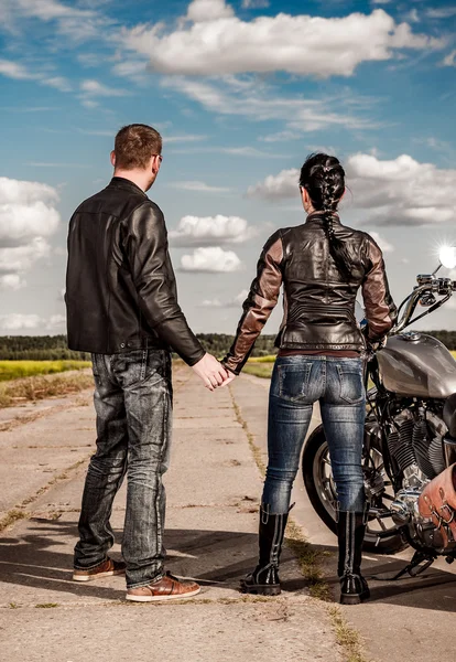 Biker man and girl stands on the road — Stock Photo, Image