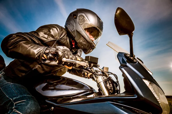 Motociclista en el casco de carreras en la carretera — Foto de Stock