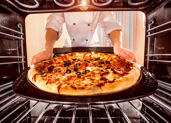 Koch kocht Pizza im Ofen. — Stockfoto