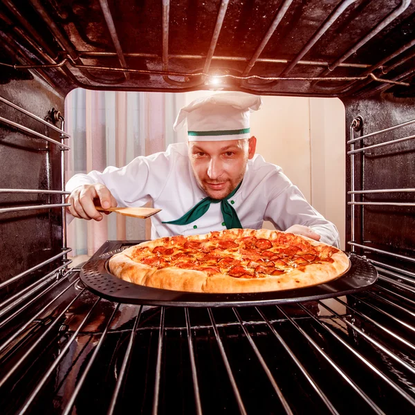 Кухар готує піцу в духовці . — стокове фото