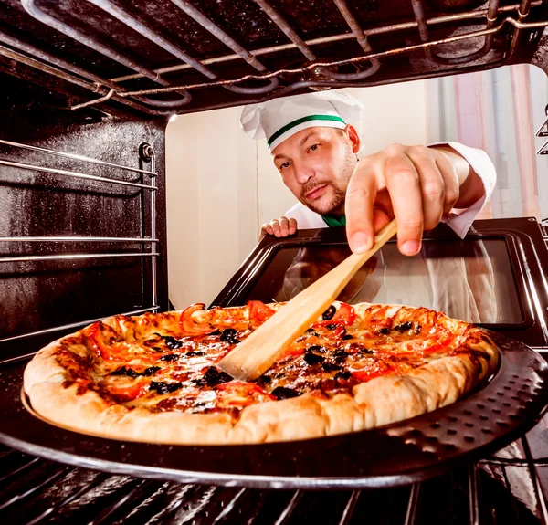 Koch bereitet Pizza im Ofen zu — Stockfoto