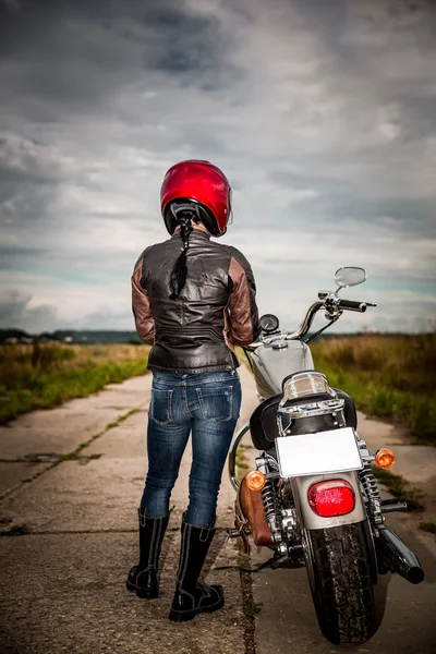 Motoqueiro menina fica na estrada e olha para a distânciamenina — Fotografia de Stock