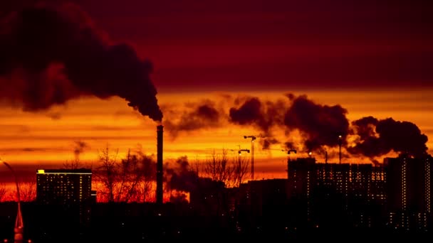 Moderne by om aftenen ved solnedgang. Røg kommer ud af rørene . – Stock-video