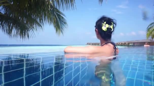 Girl looking at the ocean while sitting by the pool — Stock Video