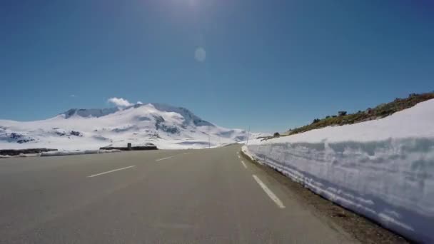 Conduire une voiture sur une route de montagne en Norvège avec un mur de neige élevé — Video