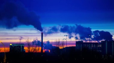 Günbatımında modern şehir. Duman, metropolün dışındaki elektrik santrallerinin ve modern mahallenin fabrikalarının borularından geliyor. Kentleşme.