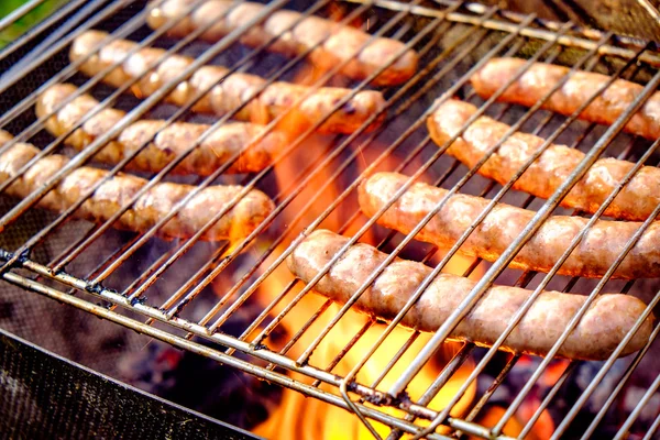 Grilling sausages on barbecue grill — Stock Photo, Image