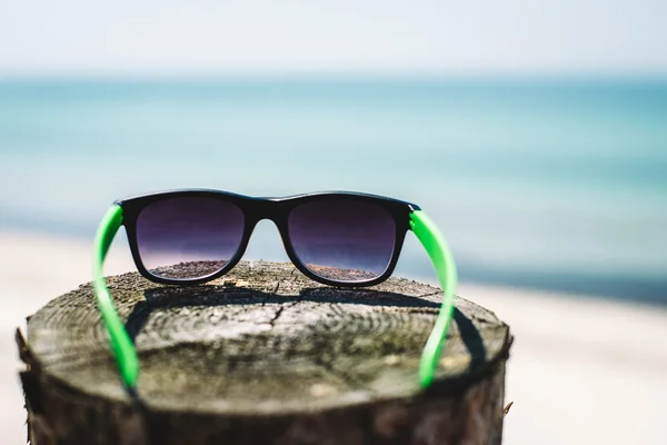 Gafas de sol en la playa o el mar —  Fotos de Stock