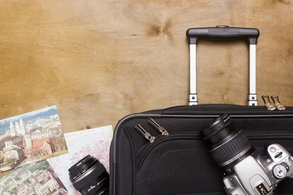 Reizigers koffer met apparatuur met camera en oude prentbriefkaar — Stockfoto