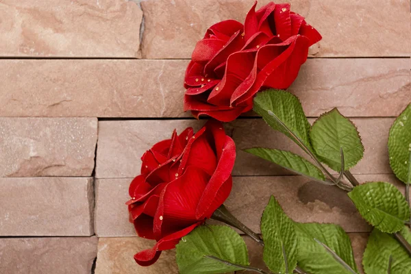 Único rosa vermelha contra um fundo texturizado — Fotografia de Stock