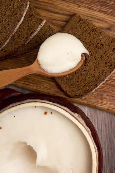 Gordura derretida e pão castanho na tábua de cortar — Fotografia de Stock