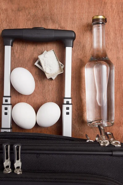 Zwarte koffer, een fles wodka en voedsel — Stockfoto