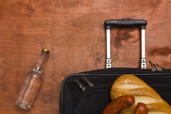 Black suitcase, a bottle of vodka and food — Stock Photo, Image