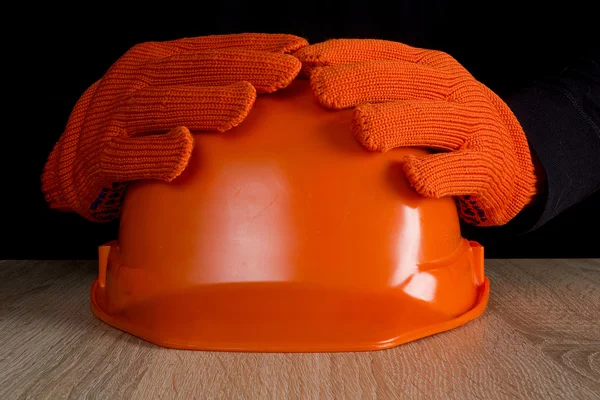 Capacete de construção laranja nas mãos — Fotografia de Stock