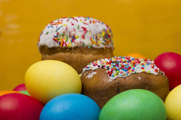 Ostereier in verschiedenen Farben und Kuchen — Stockfoto