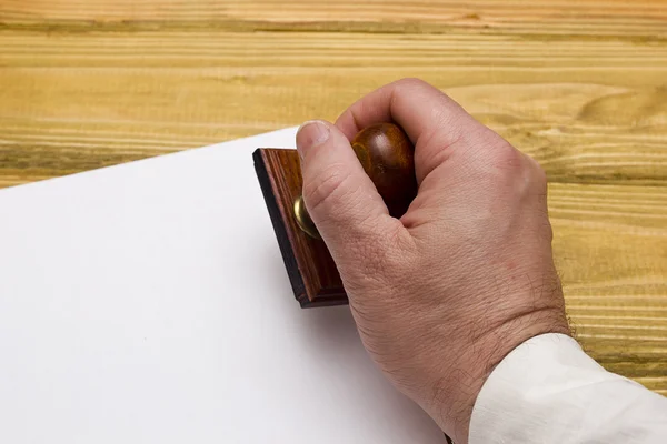 Wooden stamp in hand — Stock Photo, Image