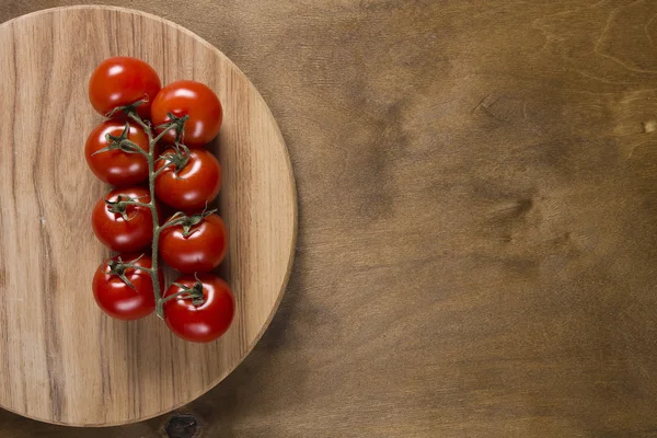 Tomato branch on vintage wood table — Stock Photo, Image