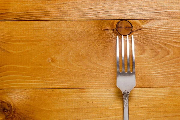 Tenedor sobre fondo de madera — Foto de Stock