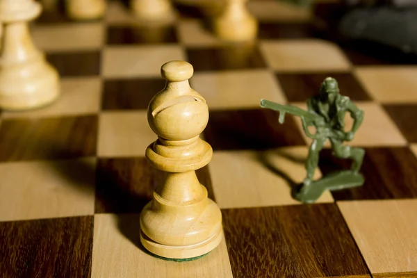 Chess pieces and toy soldiers — Stock Photo, Image