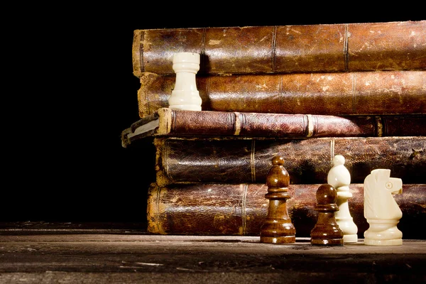 Alte Bücher und Schachfiguren — Stockfoto