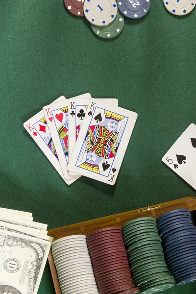 Cartões com mão de poker com fichas e dinheiro — Fotografia de Stock